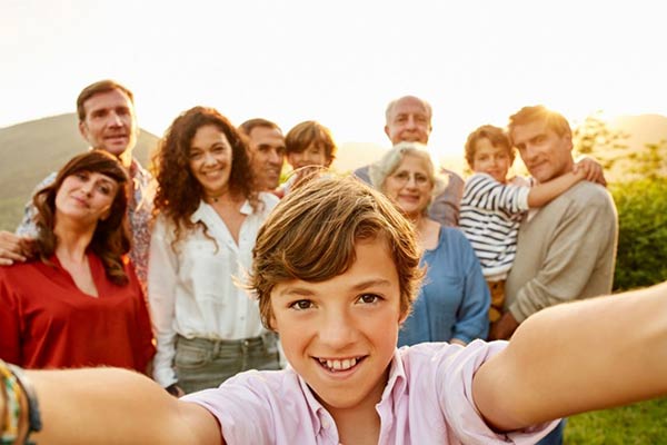 Portrait of smiling boy against family in yard