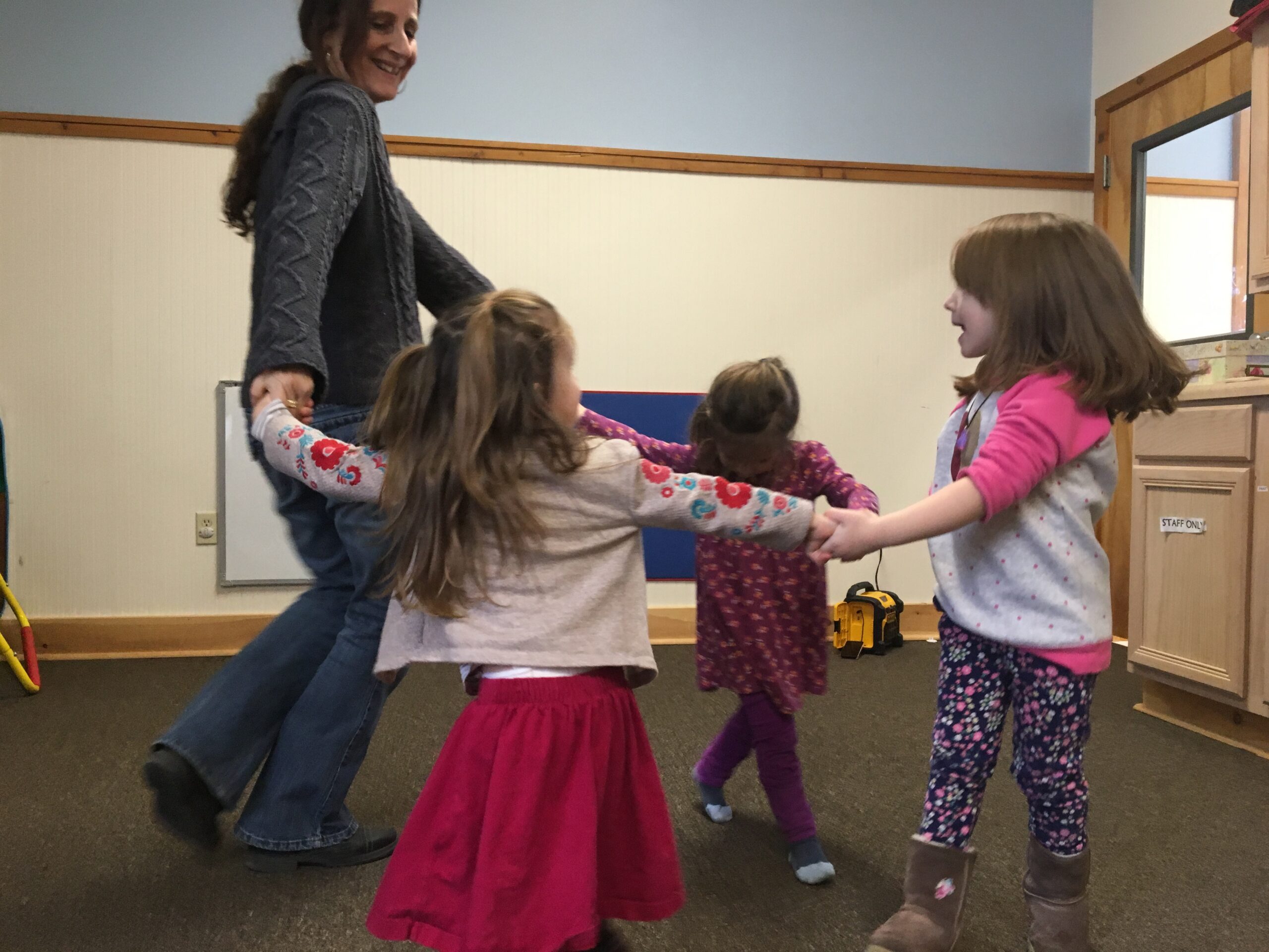 Teacher and children dancing at playgroup
