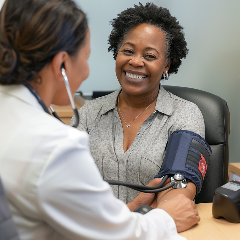 A middle-aged woman of color gets her blood pressure checked at a CHP Mobile Health Clinic.