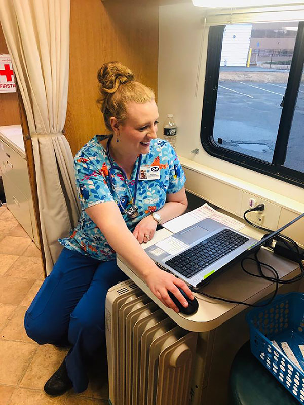 Nurse using telemedicine to speak to patient from mobile health unit